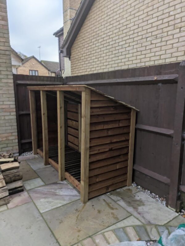 8ft x 7ft wooden log store with slanted roof and open front for firewood.