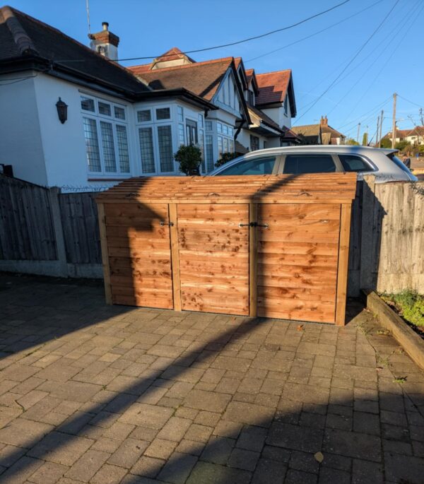 Triple bay wooden wheelie bin storage unit with hinged lids, designed for neat outdoor organization.